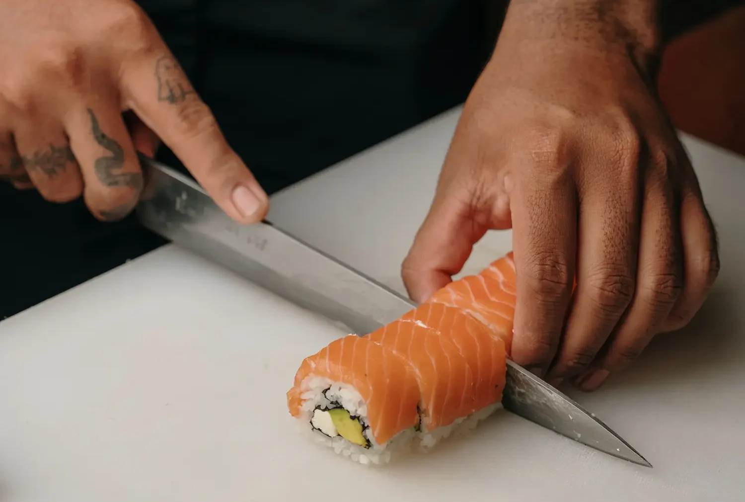 Chef slicing a sushi roll with precision, part of the sushi chef stories behind every plate