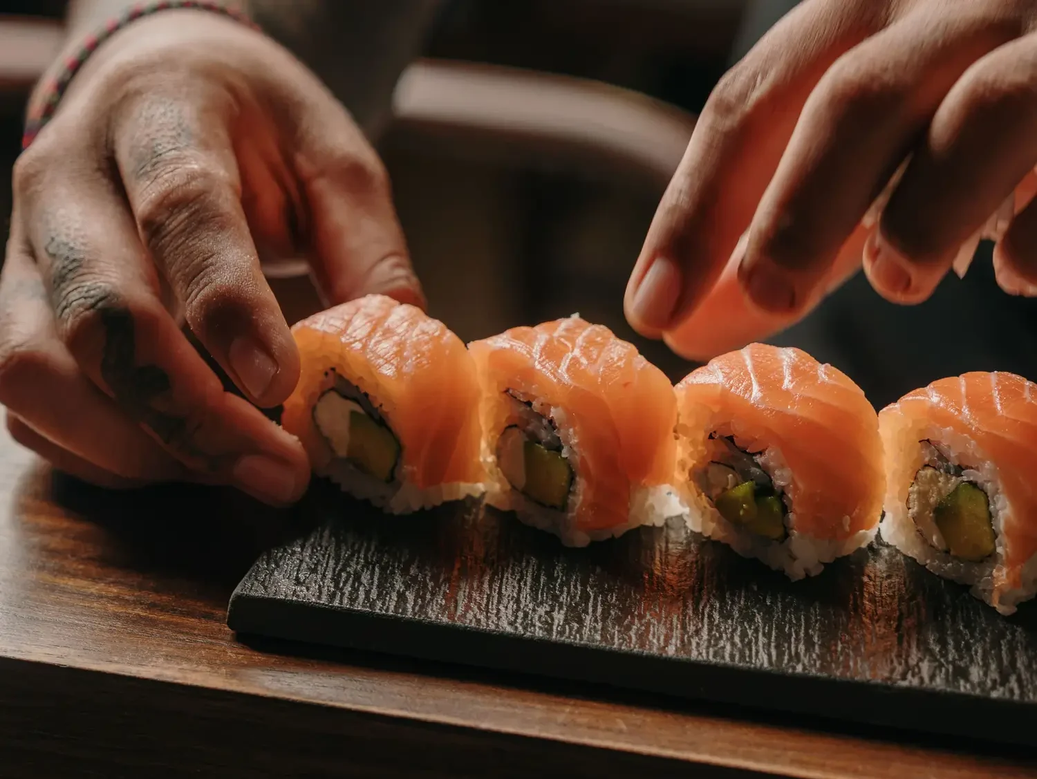 Two hands rolling sushi together, capturing the hands-on craft of a sushi journey Ubud experience