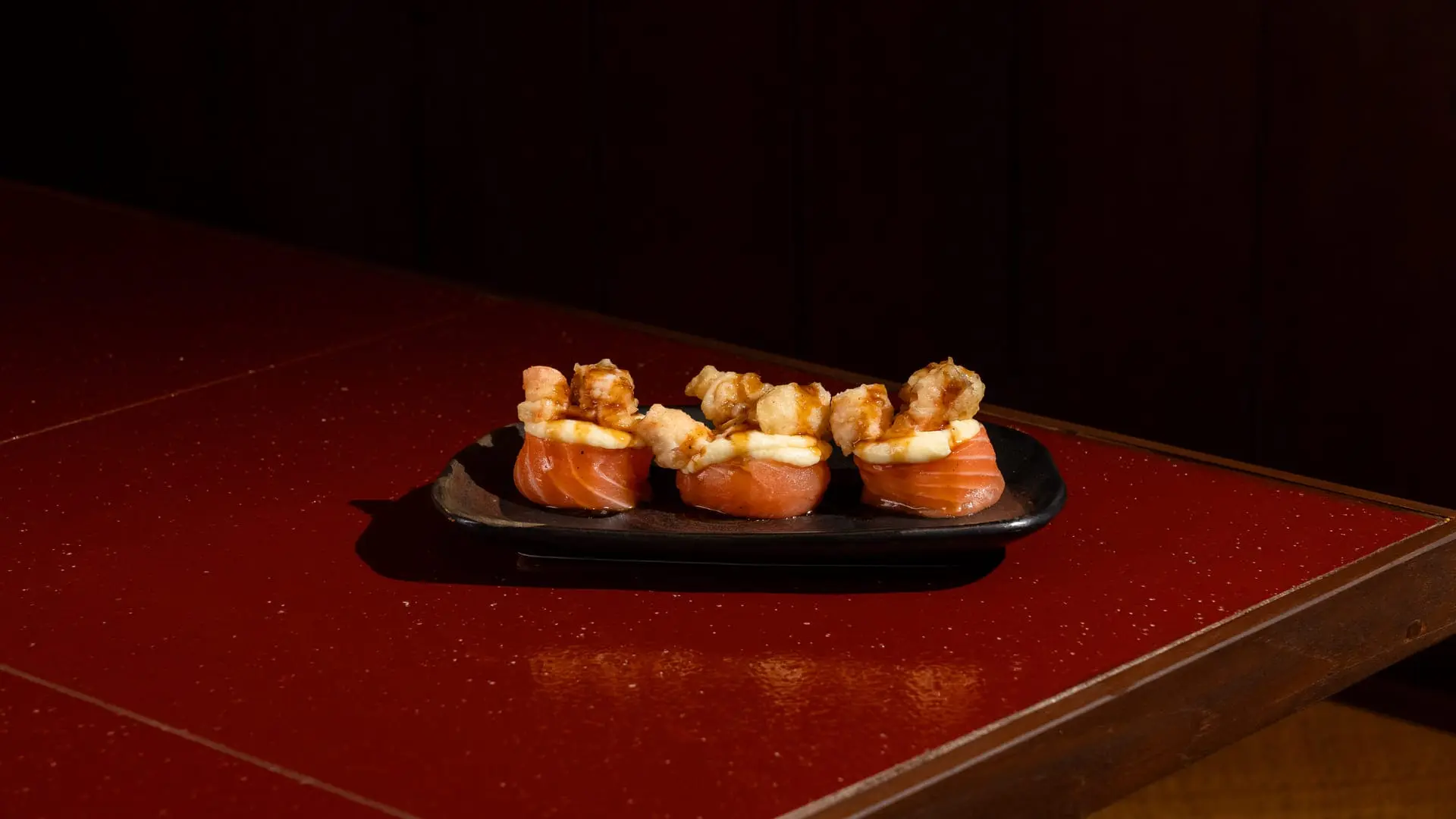 Close-up of Hana Tempura gunkan topped with prawn tempura and teriyaki sauce at Shinraku